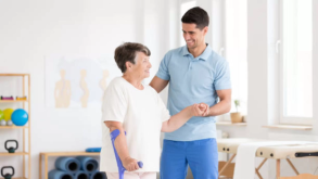 Young Man Helping Elderly Woman To Walk