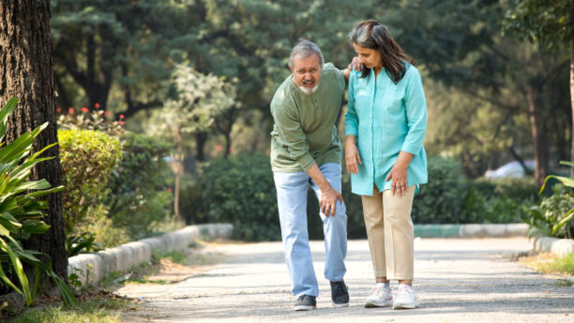 Man Feels Knee Pain While Walking Outdoors With His Partner